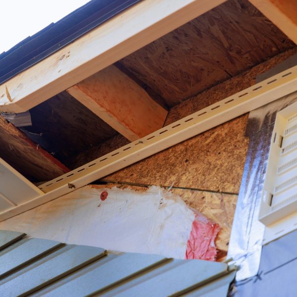 Soffit board in white vinyl uPVC installed along roofline of a house below fascia roof.